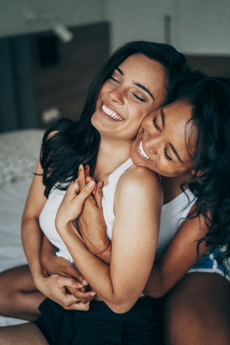 Lesbian Couple Embracing Each Other on the Bed