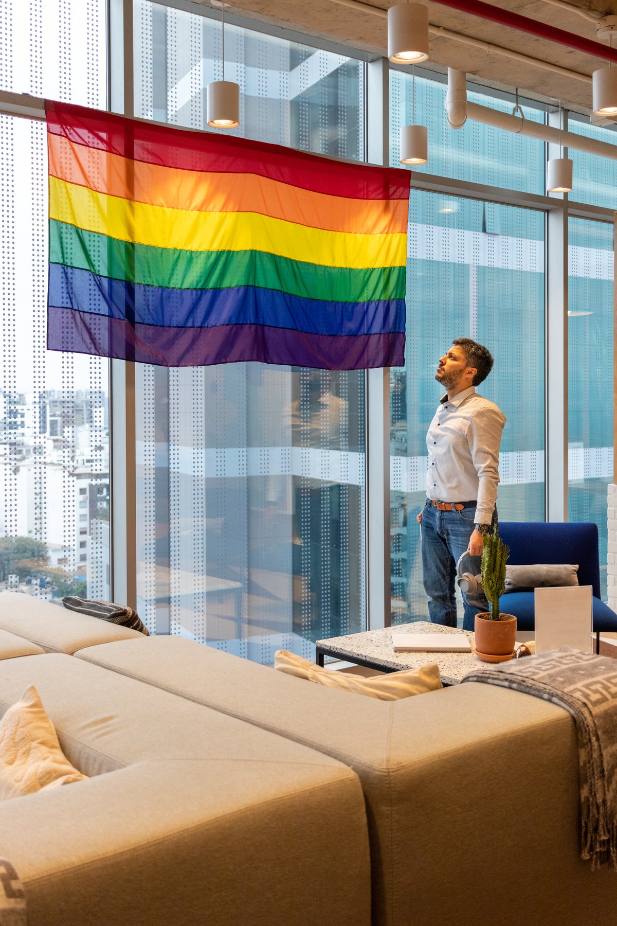 Man Looking at LGBT Flag on the Window